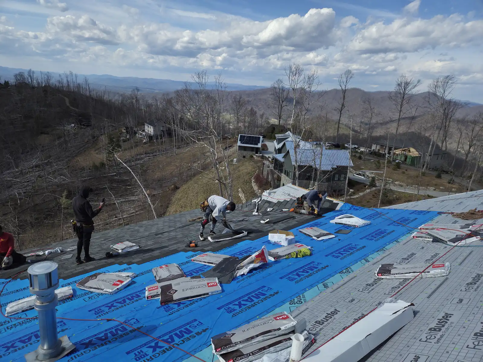 Crew installing underlayment mountain roof